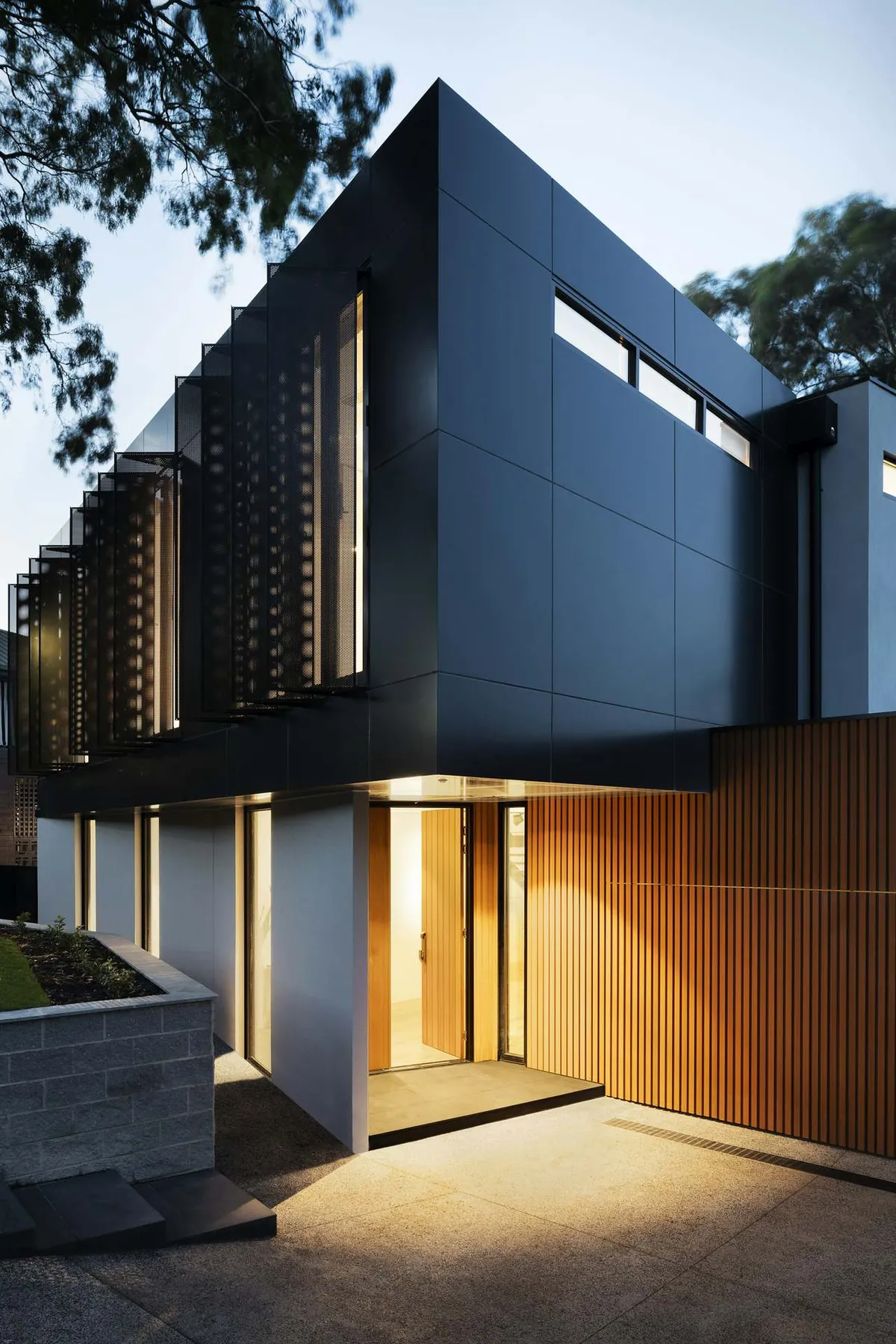 A modern home at dusk with warm lights on