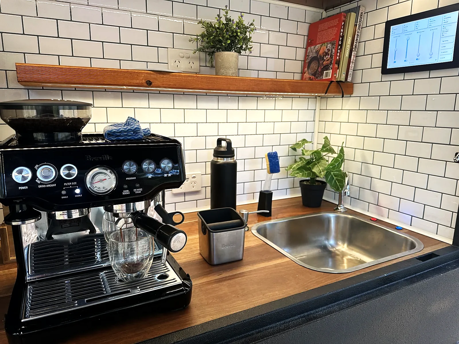 Camper kitchen with espresso machine and wall-mounted control screen