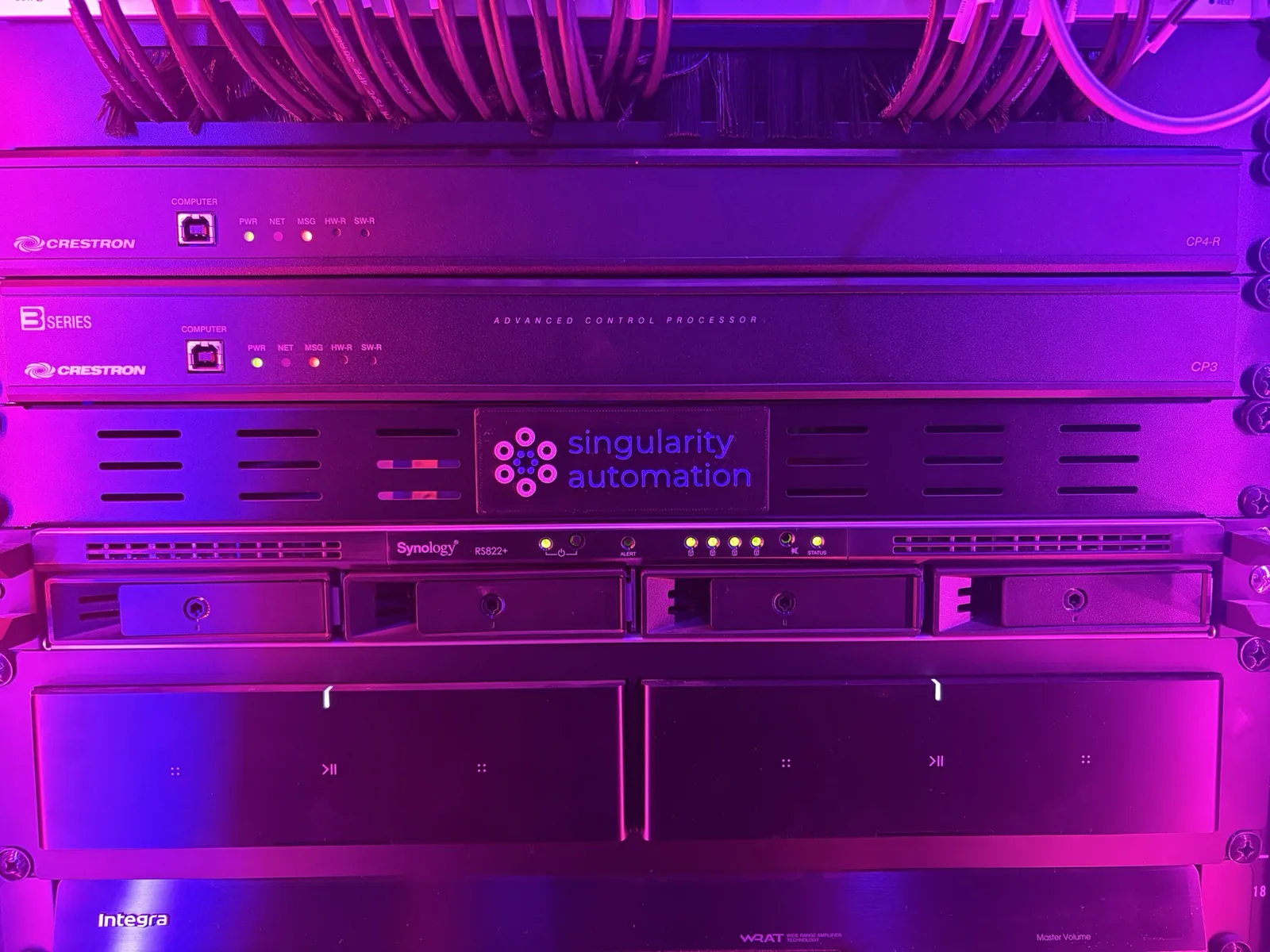Crestron processors and a Singularity Automation panel in a home equipment rack